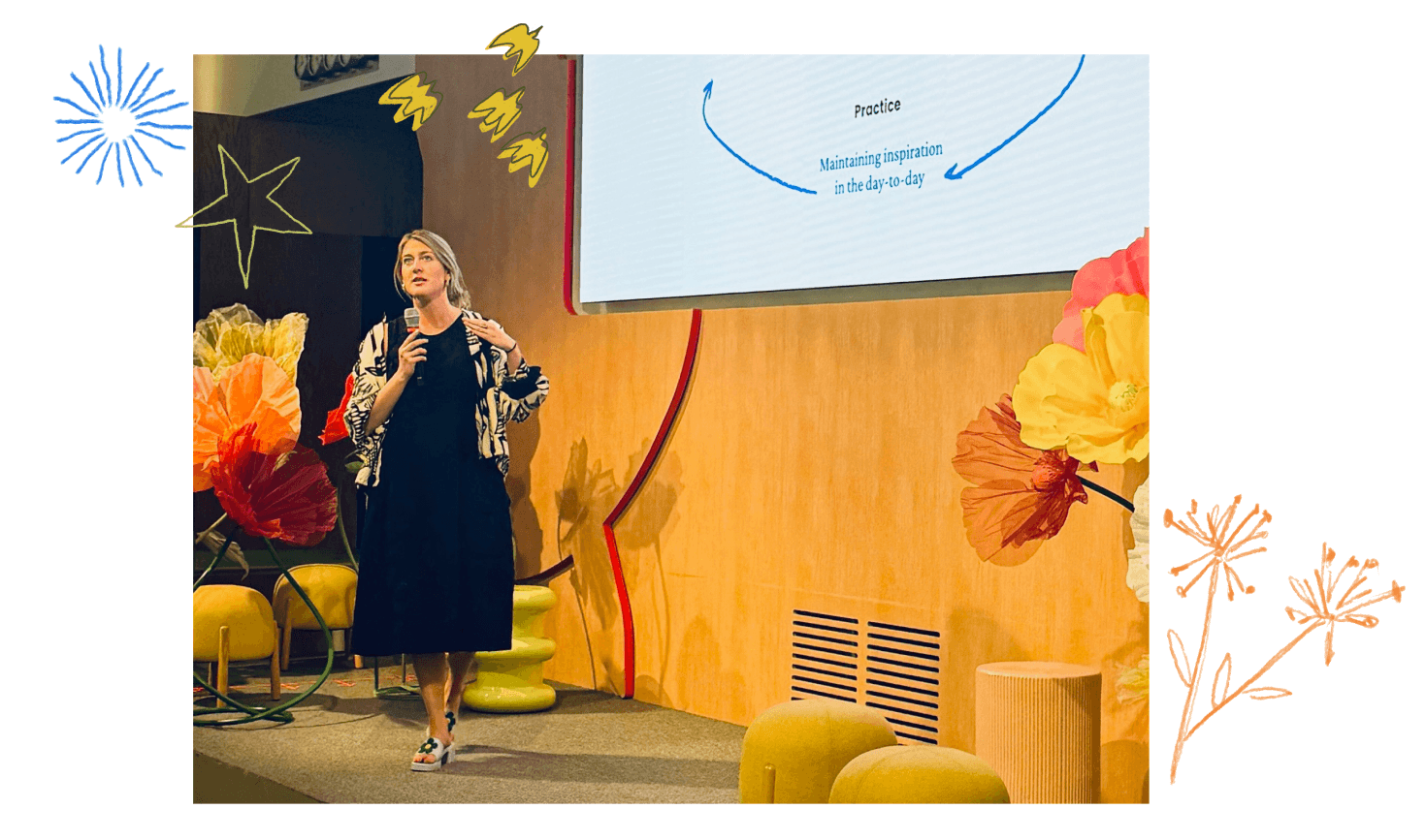 The author presenting on stage, holding a microphone and gesturing, presenting in front of a screen with a diagram about inspiration.